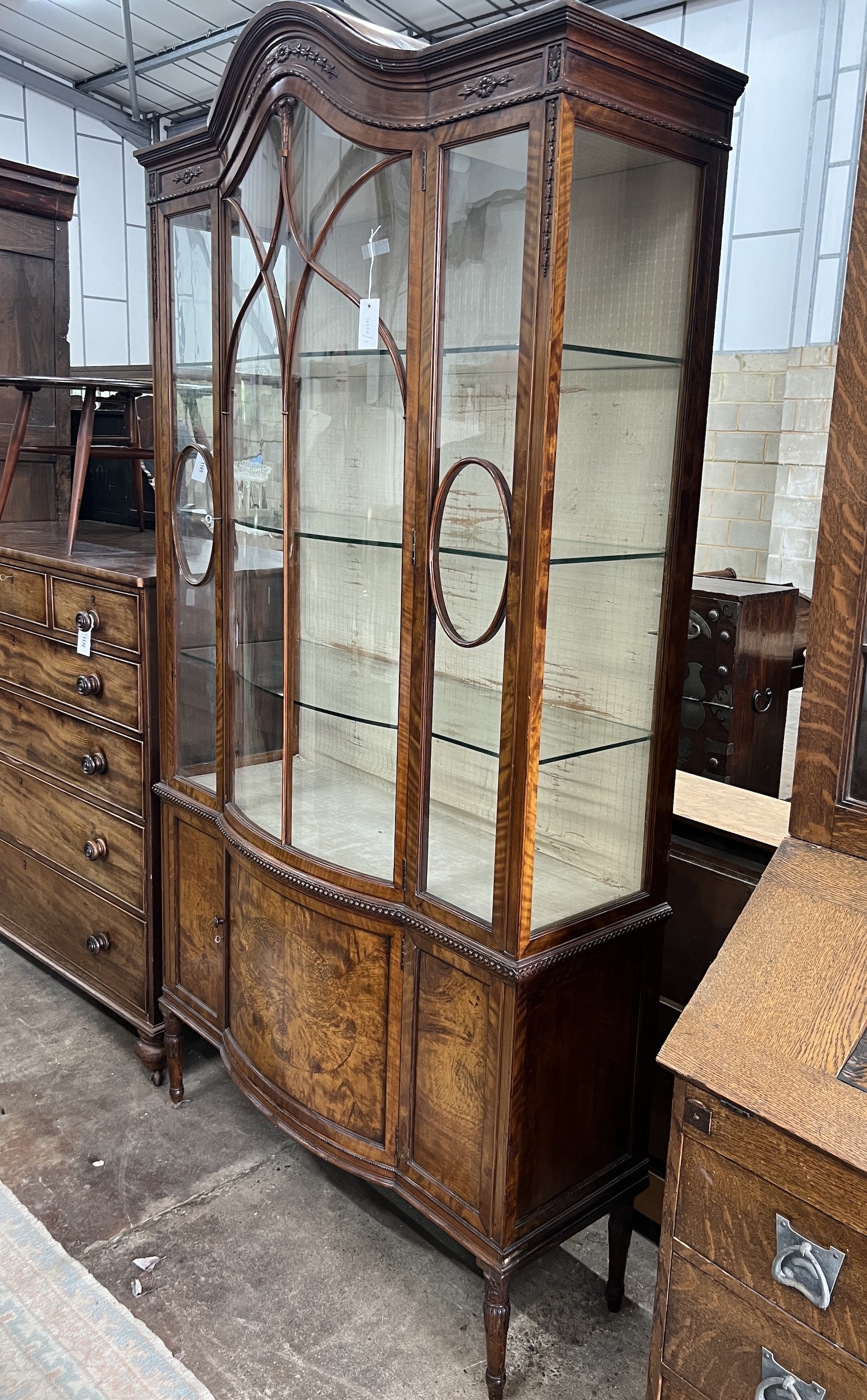 A 1920's Sheraton revival satinwood bowfront display cabinet, width 114cm, depth 42cm, height 211cm